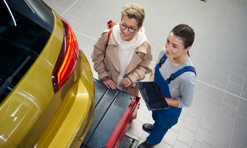 A Volkswagen on a lifting platform during a Main Inspection Pre-Check