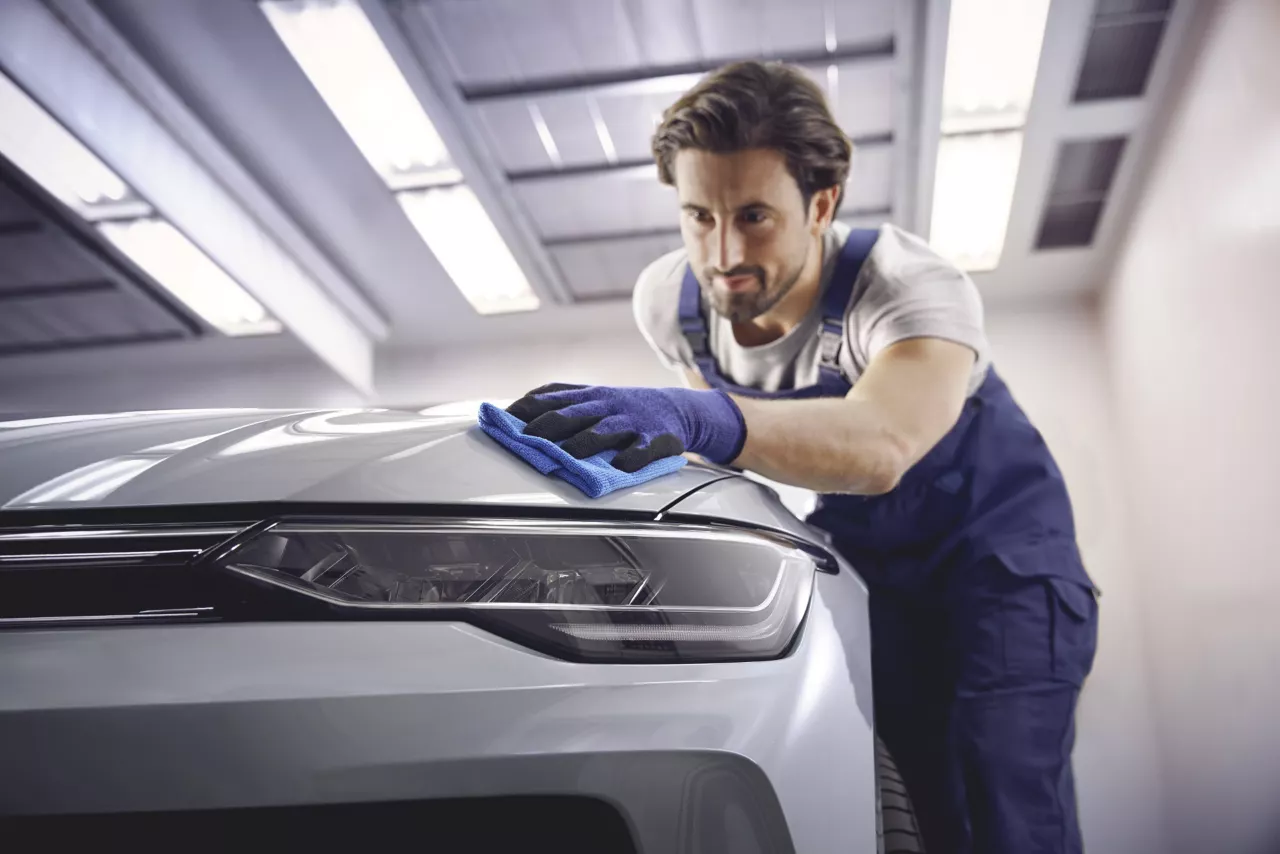 A Volkswagen technician finishing a body repair