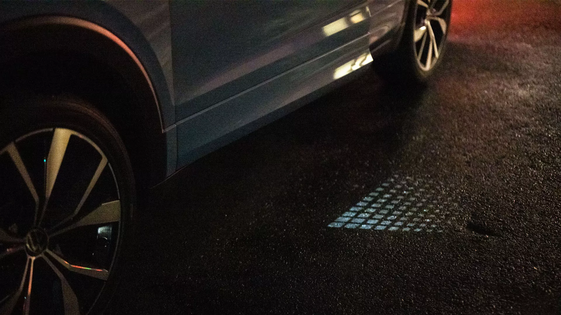 The driver’s door from above, only a crack open, with light projecting visibly in the twilight.