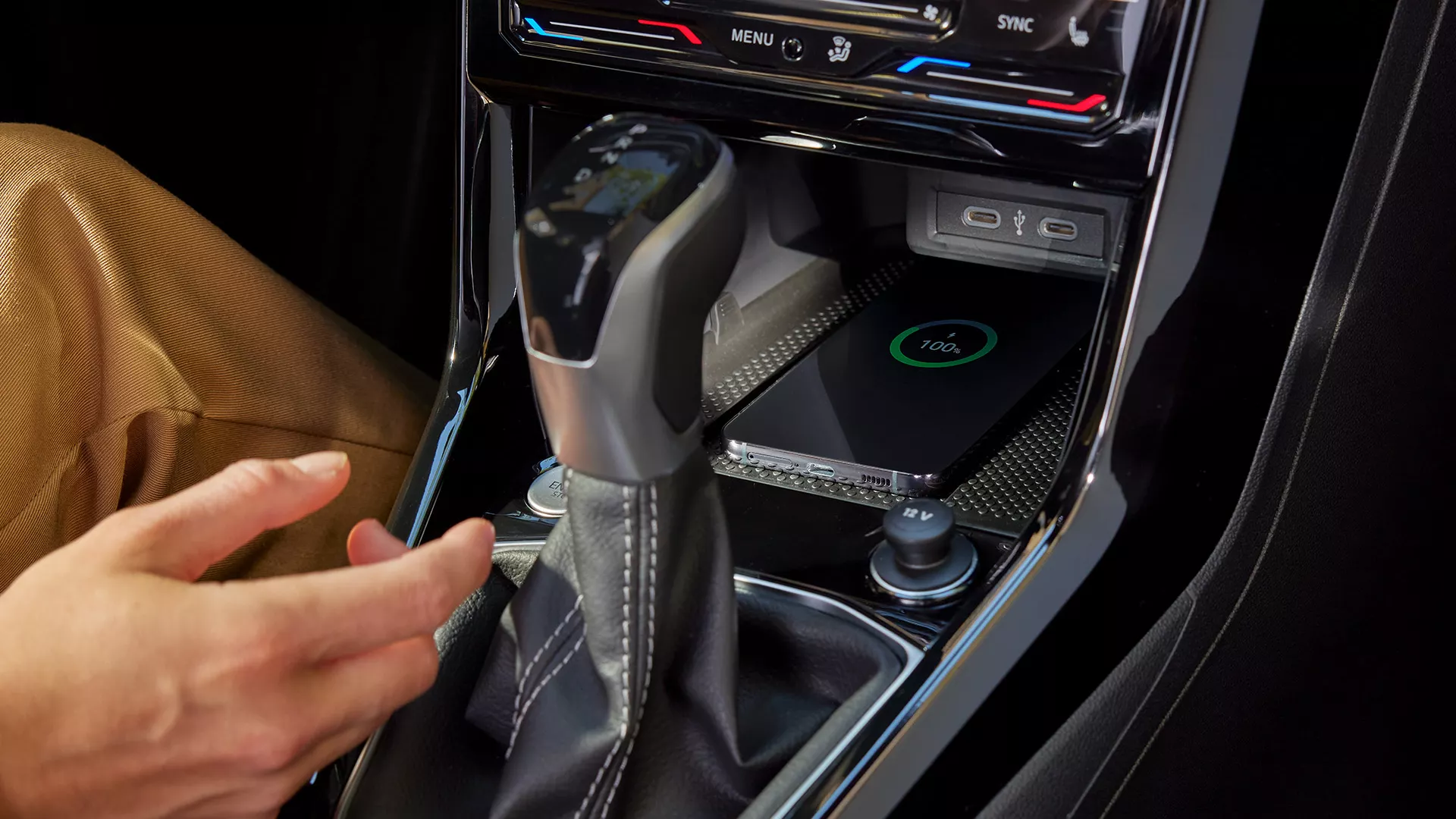 Detailed view of the wireless charging pad with a smartphone placed on it to charge.