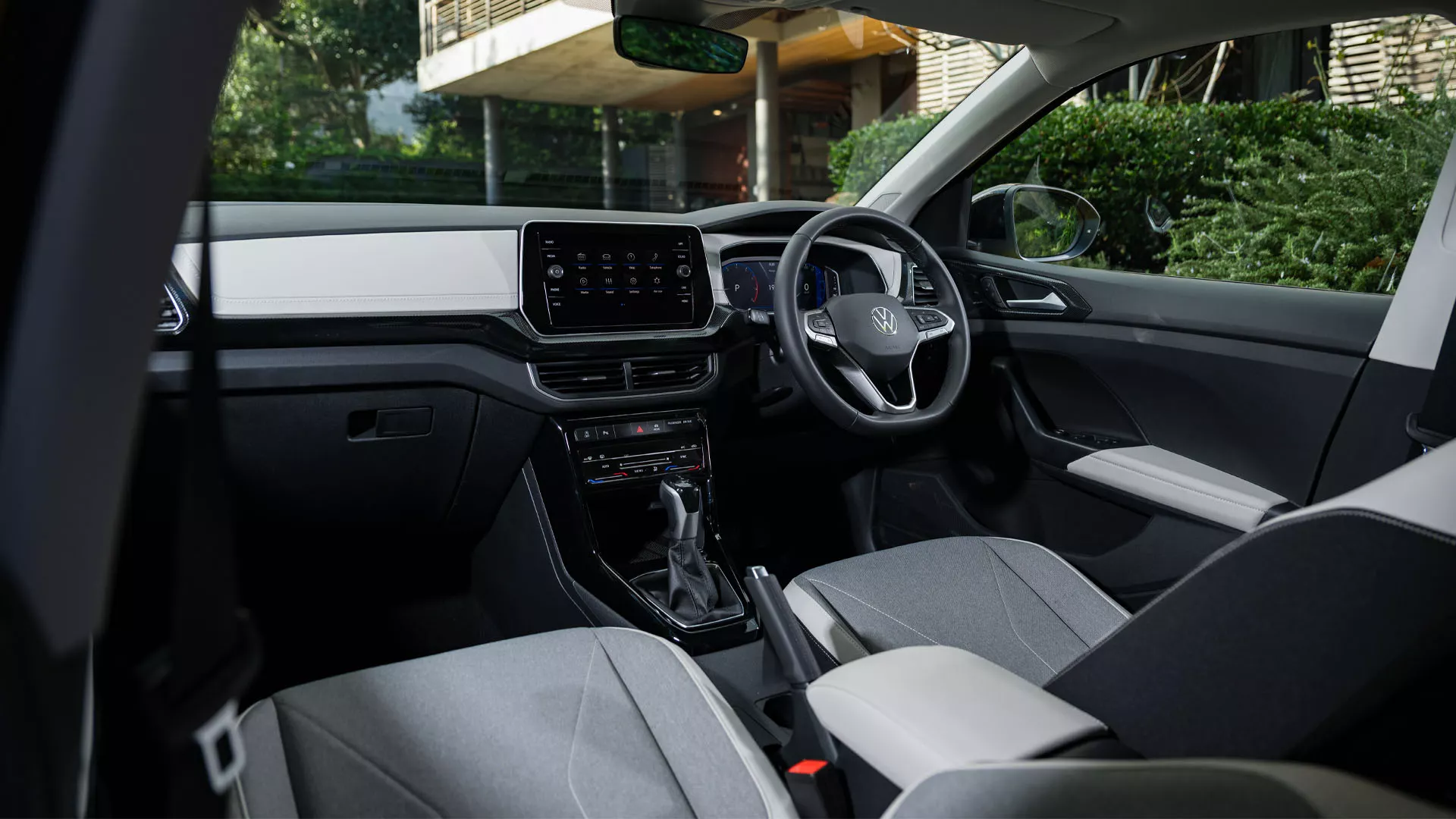 View of the cockpit through the passenger window in a VW T-Cross parked in the city