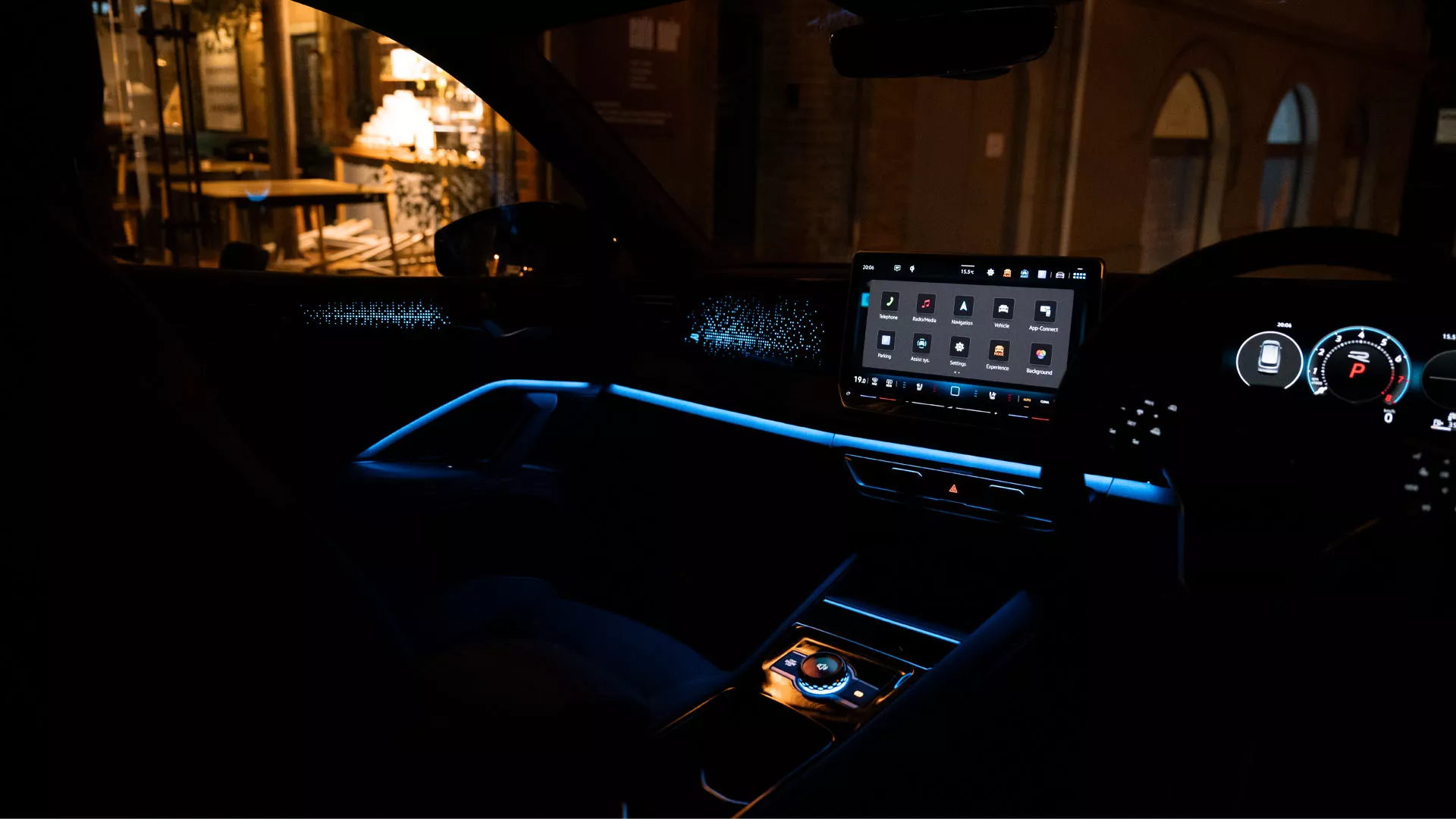 Interior view of the VW Tiguan at night, colour display shows the optional background lighting settings, interior is illuminated in green.