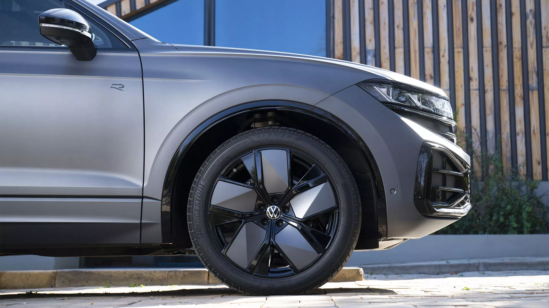 A VW Touareg Elegance at dusk by the sea with the HD matrix headlights switched on.